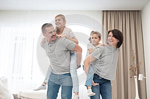 Mother And Father Giving daughters Piggyback in living room