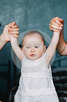 Mother and father hands holding little toddler girl