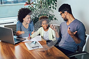 Mother and father helping daughter to do homework learning to calculate