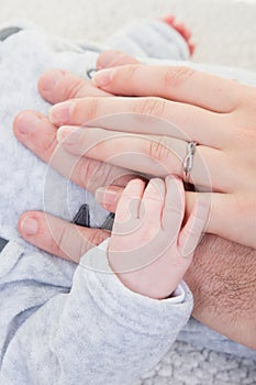 Mother father with her newborn baby care hands