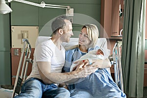 Mother and father with her newborn baby at the hospital a day after a natural birth labor