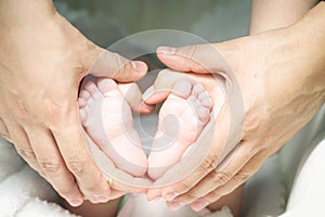 Mother and father holding child's feet