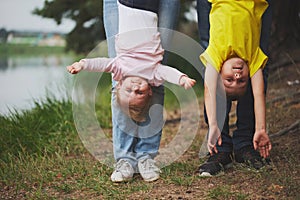 Mother and father holding son and daughter upside down