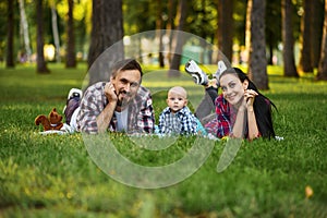 Mother, father and little baby leisures in park