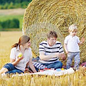 Mother, father and little son, kid boy having picnic
