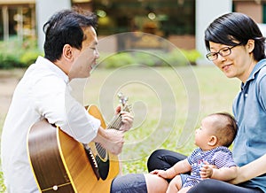 Mother and father parenting baby on park