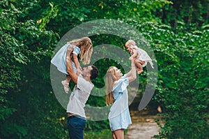 Mother and father playing with their children on a nice summer day