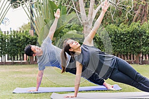 mother, father practicing doing yoga exercises with child daughter outdoors in meditate pose together