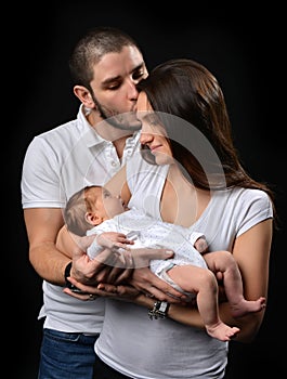 Mother and father smiling holding their newborn infant child baby boy