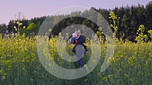 Mother, father and son dancing and playing in the rapeseed field Slow motion