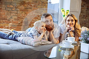 Mother, father and son at home having fun, comfort and cozy concept