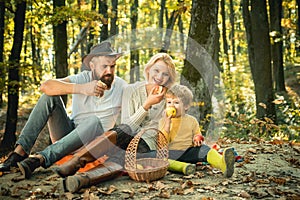 Mother father and son in picnic. Family Picnic in nature. Happy family with kid boy relaxing while hiking in forest