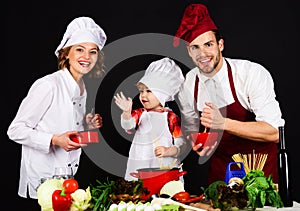Mother, father and son preparing breakfast or dinner in kitchen. Parents teaching boy how to cook. Happy family cooking