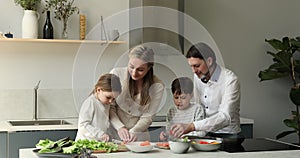 Mother father teach elder son younger daughter to cook salad
