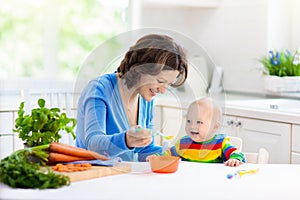 Mother feeding baby first solid food