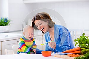 Mother feeding baby first solid food