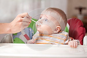 Mother feeding baby food to baby