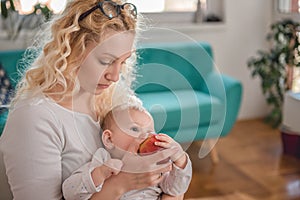 Mother feeding baby at home office