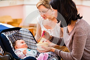 Mother feeding baby at midwife practice