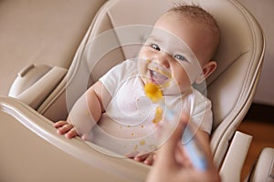 Mother feeding baby porridge using spoon