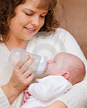Mother feeding baby son from a bottle