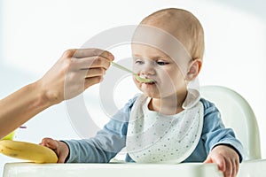 Mother feeding baby son while holding