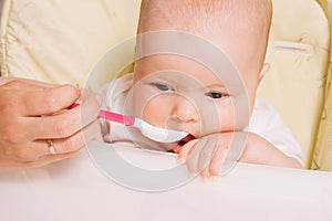 Mother feeding baby with a spoon. baked apple