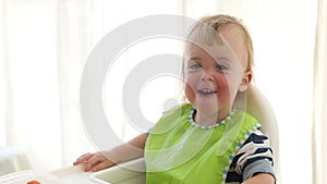 Mother feeding baby with spoon indoors