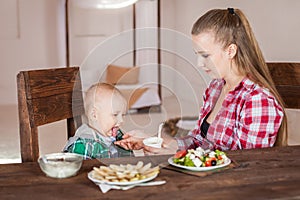 Mother feeding child. First solid food for young kid