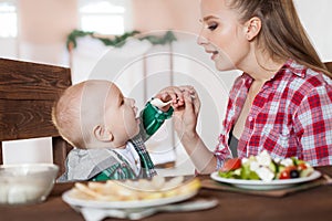 Mother feeding child. First solid food for young kid