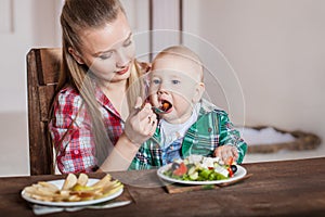 Mother feeding child. First solid food for young kid