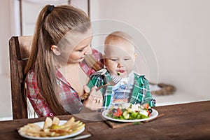 Mother feeding child. First solid food for young kid