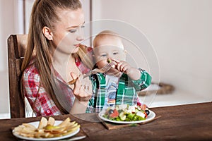 Mother feeding child. First solid food for young kid