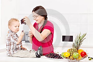 Mother feeding child in kitchen