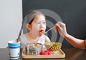 Mother feeding food for her daughter