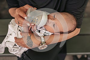 Mother feeding her adorable baby boy with a bottle