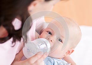 Mother feeding her baby boy with bottle