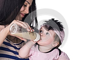 Mother feeding her baby girl from a bottle