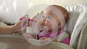 Mother Feeding her baby girl with a Spoon.