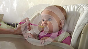 Mother Feeding her baby girl with a Spoon.