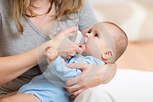 Mother feeding her baby infant from bottle