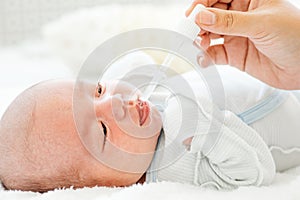 Mother feeding her baby with a milk formula from a bottle