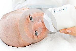 Mother feeding her baby with a milk formula from a bottle