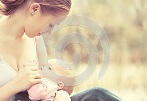 Mother feeding her baby in nature outdoors in the park photo