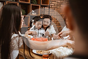 Mother feeding her boy son during family gathering