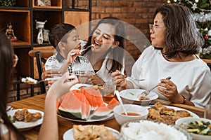 Mother feeding her boy son during family gathering