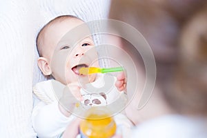 Mother feeding her lovely baby boy with spoon