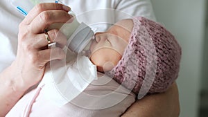 Mother feeding her newborn baby milk formula from a bottle