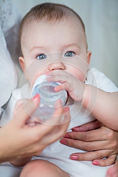 Mother feeding his baby boy by milk from bottle