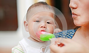 Mother feeding ice-cream for five month old infant baby boy
